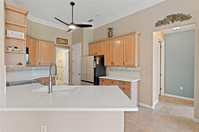 kitchen featuring fridge, kitchen peninsula, sink, and backsplash