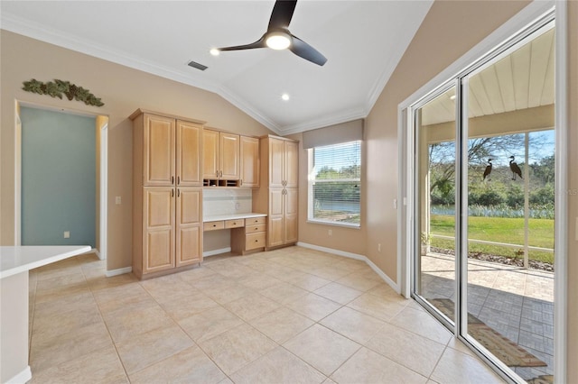 kitchen with lofted ceiling, ceiling fan, built in desk, light tile patterned flooring, and light brown cabinetry