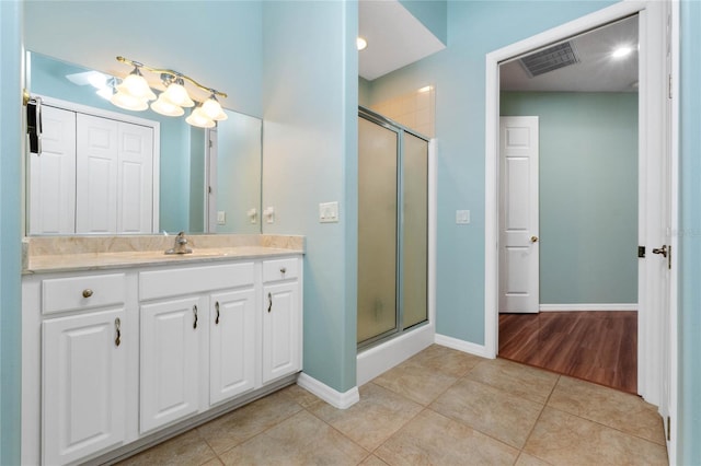 bathroom with vanity, a shower with shower door, and tile patterned flooring