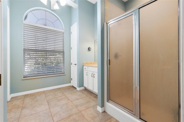 bathroom featuring vanity, a healthy amount of sunlight, tile patterned floors, and a shower with shower door