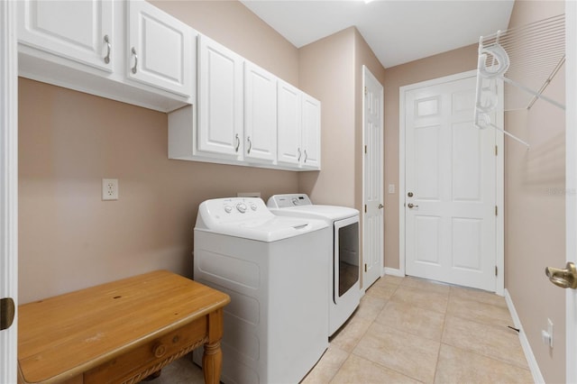 clothes washing area featuring light tile patterned floors, cabinets, and independent washer and dryer