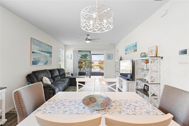 dining area featuring ceiling fan with notable chandelier and hardwood / wood-style flooring