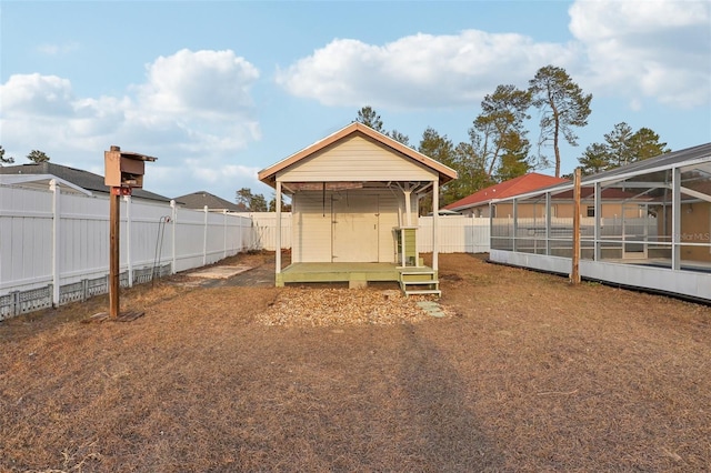 exterior space with a storage shed, glass enclosure, and a fenced backyard