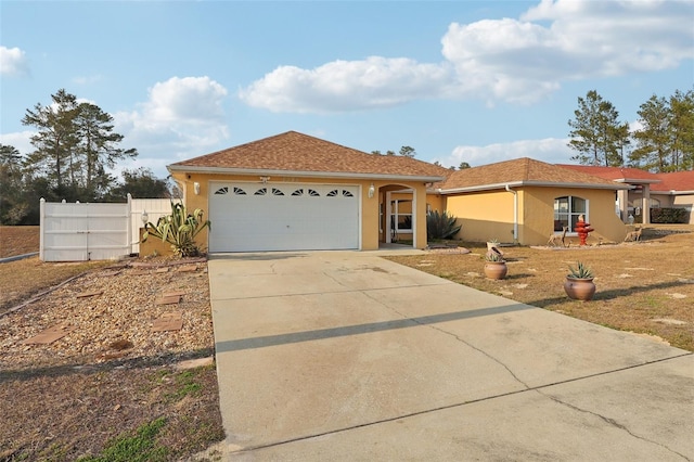 ranch-style house featuring roof with shingles, stucco siding, concrete driveway, an attached garage, and fence