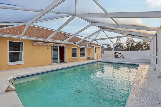 view of pool with glass enclosure, fence, a fenced in pool, and a patio