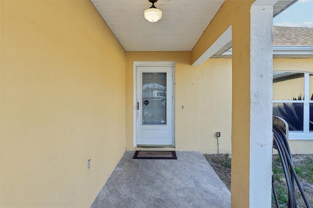 property entrance featuring a patio and stucco siding