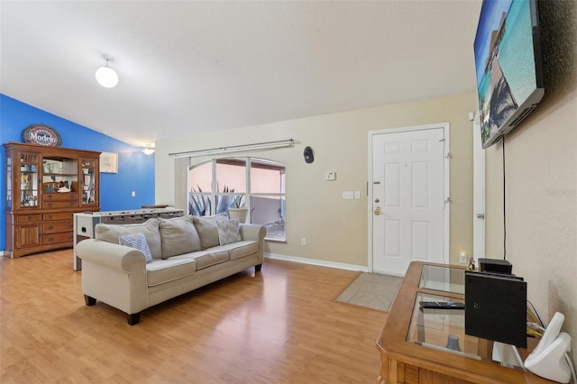 living room with lofted ceiling, wood finished floors, and baseboards