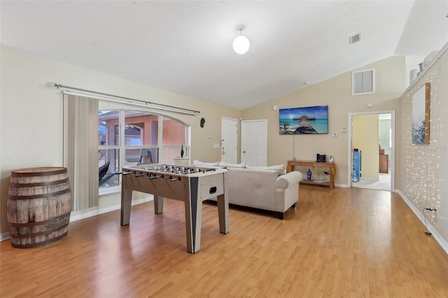 recreation room with light wood-style floors, lofted ceiling, and visible vents