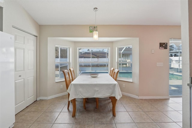 dining area featuring light tile patterned floors and baseboards