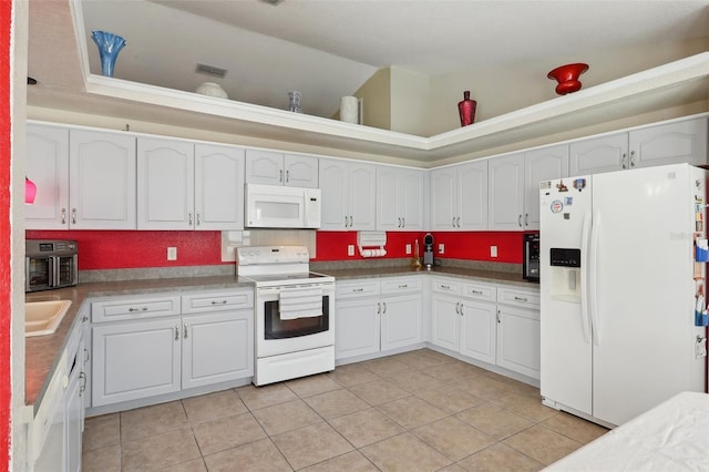 kitchen with visible vents, white appliances, light tile patterned floors, and white cabinetry