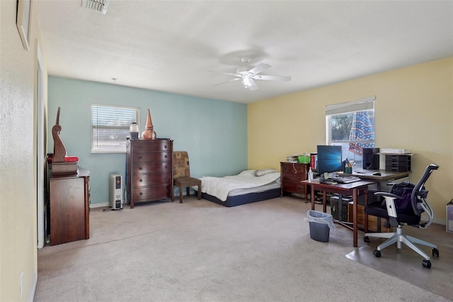 bedroom with light colored carpet, multiple windows, and visible vents