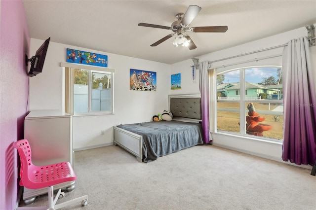 bedroom featuring a ceiling fan, light carpet, and baseboards