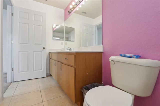 bathroom featuring visible vents, a textured wall, toilet, tile patterned flooring, and vanity