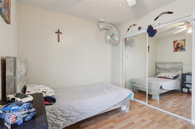 bedroom with a closet, ceiling fan, and wood finished floors