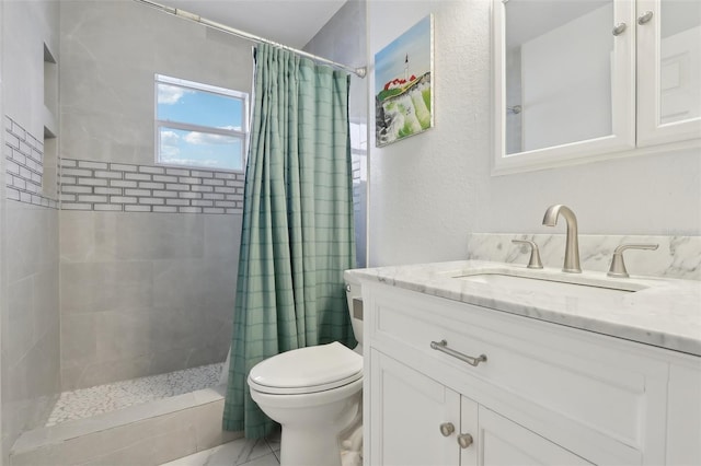 full bath featuring toilet, a tile shower, and vanity