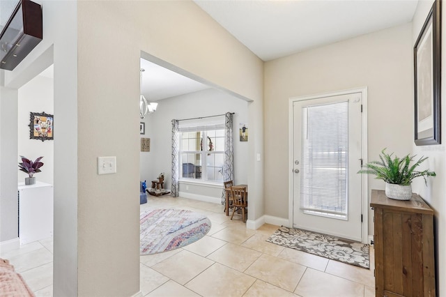 foyer entrance with light tile patterned flooring and a chandelier