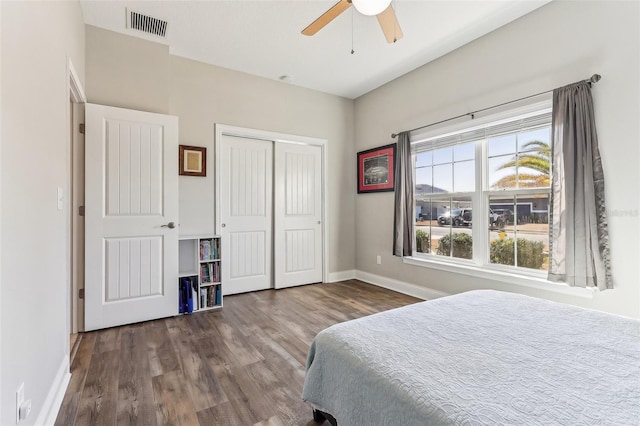 bedroom with ceiling fan, dark hardwood / wood-style flooring, and a closet