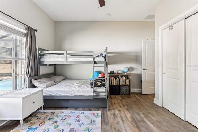 bedroom featuring ceiling fan, hardwood / wood-style floors, and multiple windows