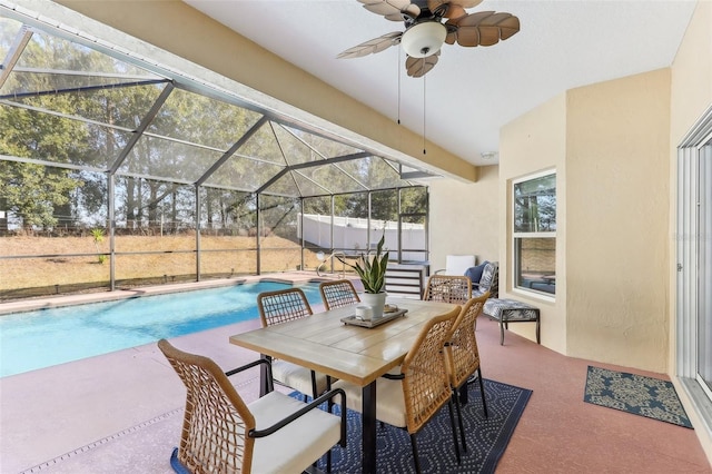 view of swimming pool featuring ceiling fan, a patio area, and glass enclosure