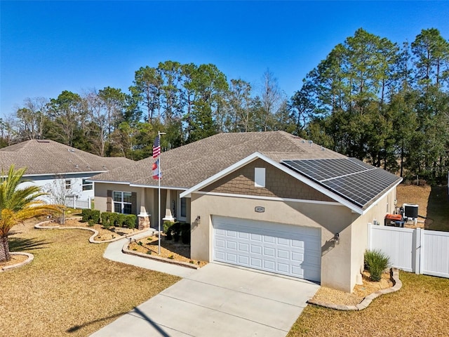 single story home featuring a garage, cooling unit, and solar panels