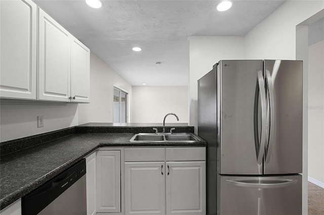 kitchen with sink, tile patterned flooring, stainless steel appliances, a textured ceiling, and white cabinets