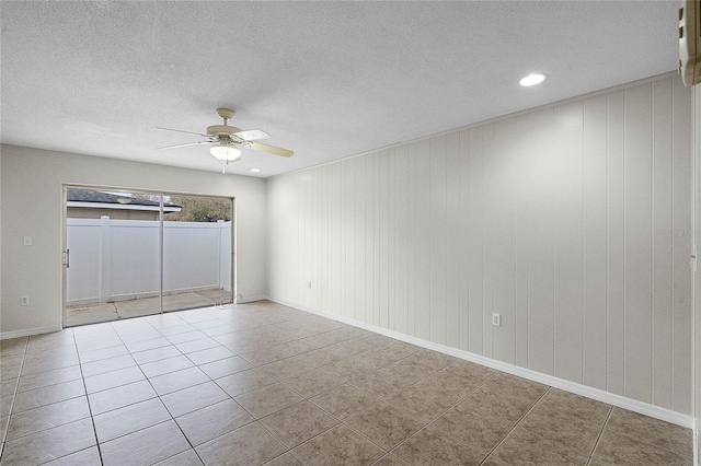 unfurnished room with ceiling fan, tile patterned flooring, and a textured ceiling