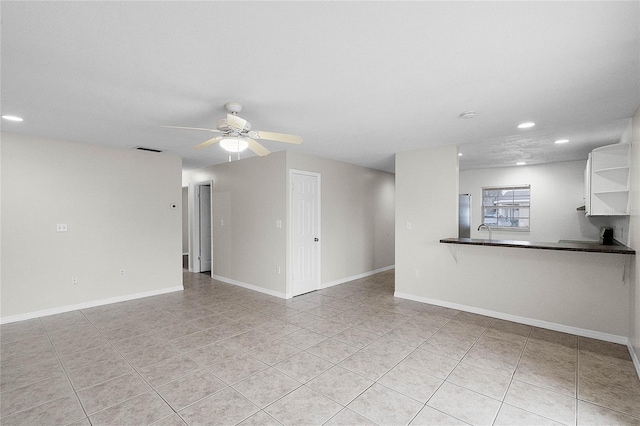 unfurnished living room with light tile patterned floors, sink, and ceiling fan