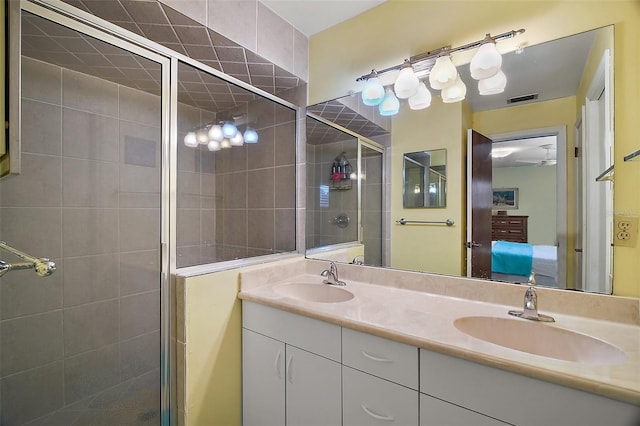 bathroom featuring double vanity, a shower stall, ensuite bath, and a sink