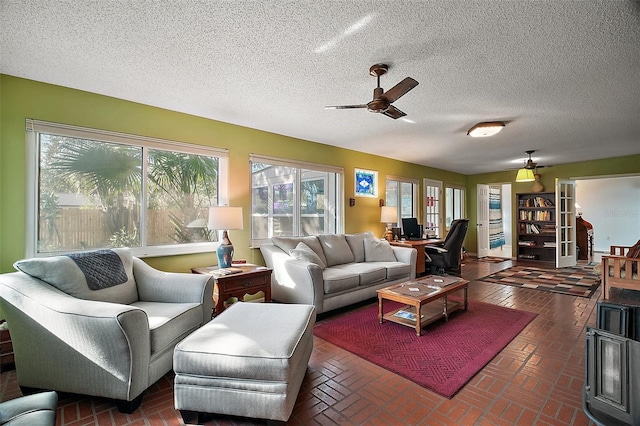 living area featuring a ceiling fan, brick floor, and a healthy amount of sunlight