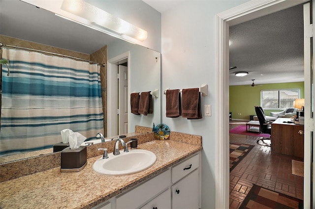 full bathroom with a shower with curtain, vanity, a textured ceiling, and brick patterned floor