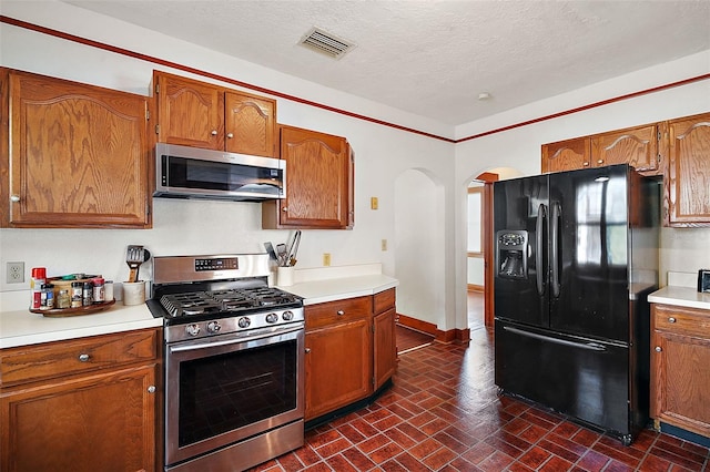 kitchen with a textured ceiling and appliances with stainless steel finishes