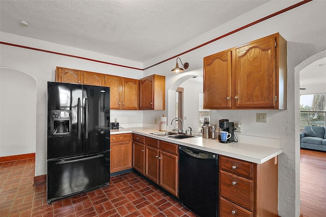 kitchen with sink, a textured ceiling, and black appliances