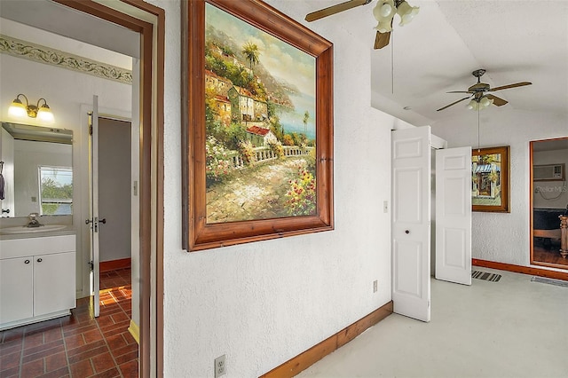 corridor featuring lofted ceiling, sink, and a wall unit AC