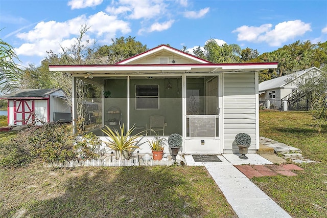 view of front of home with a storage unit and a front lawn