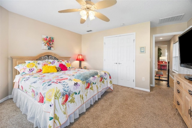 bedroom with light colored carpet, ceiling fan, and a closet