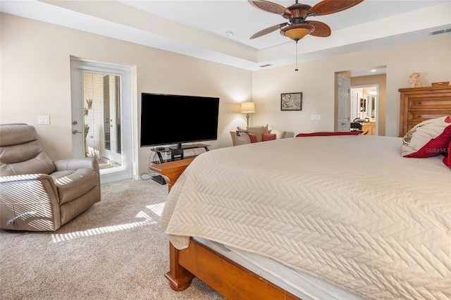 bedroom featuring a raised ceiling, light colored carpet, access to exterior, and ceiling fan