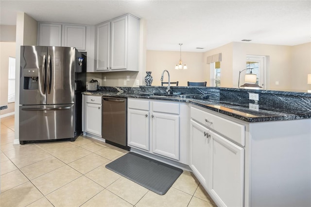 kitchen featuring white cabinetry, appliances with stainless steel finishes, dark stone countertops, and light tile patterned floors