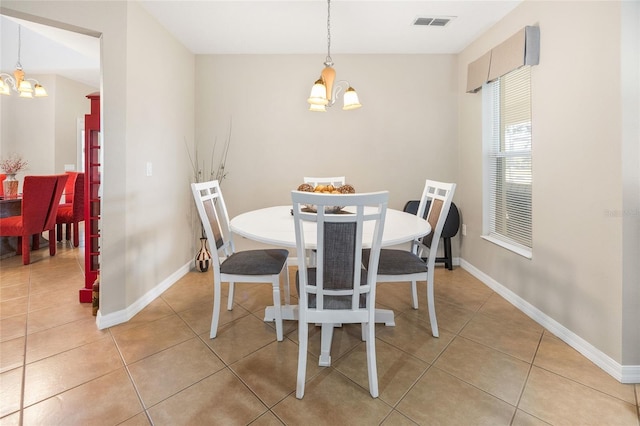 dining room with a chandelier and tile patterned flooring