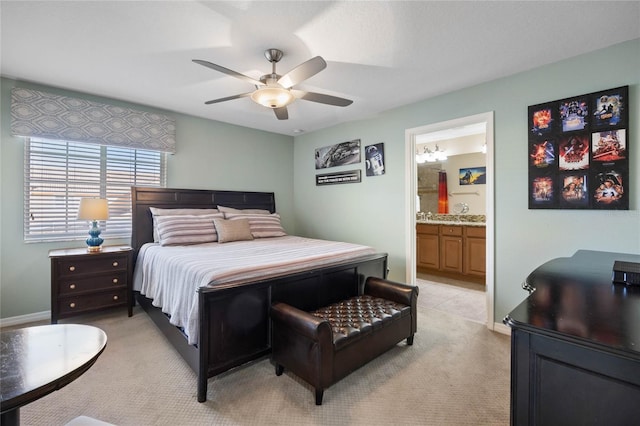 bedroom with connected bathroom, light colored carpet, and ceiling fan