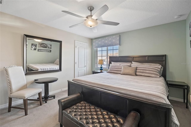 bedroom with ceiling fan, light colored carpet, and a textured ceiling