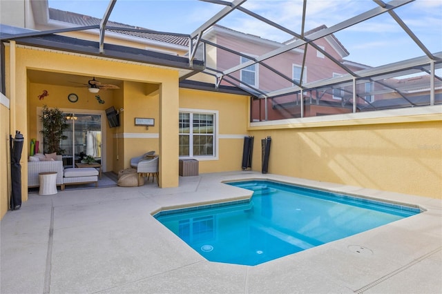 view of pool with ceiling fan, glass enclosure, and a patio area