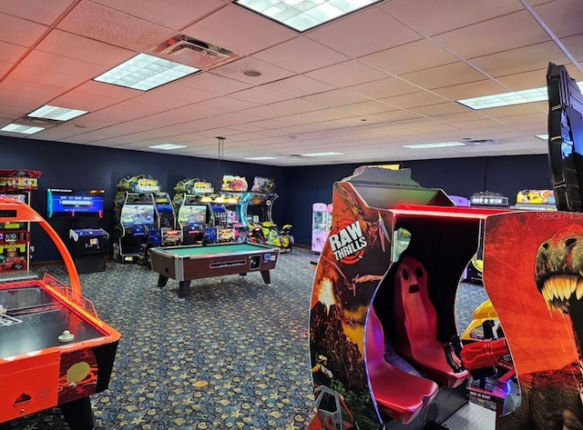 recreation room featuring a paneled ceiling and carpet flooring