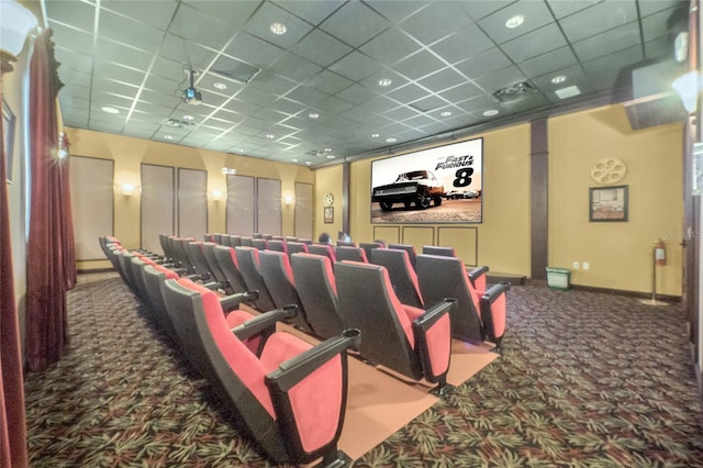 home theater with a paneled ceiling and dark colored carpet