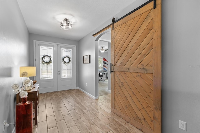 entryway featuring a barn door, light hardwood / wood-style floors, and french doors