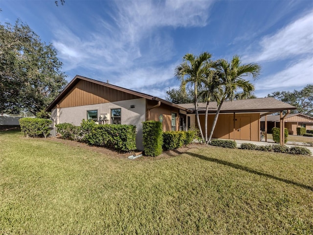 view of side of home with a carport and a lawn