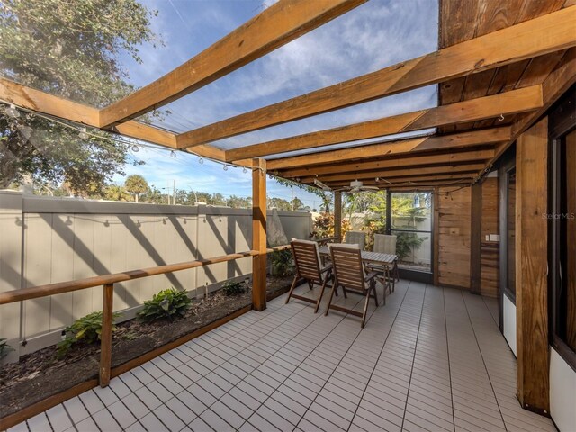 sunroom / solarium featuring beamed ceiling