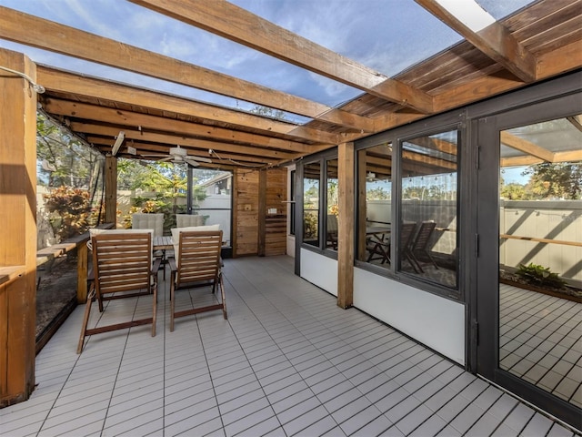 sunroom with beam ceiling and ceiling fan