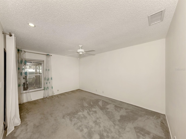 empty room featuring light carpet, a textured ceiling, and ceiling fan