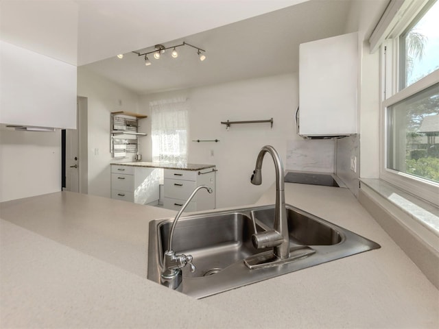 kitchen with white cabinetry, black electric stovetop, and sink