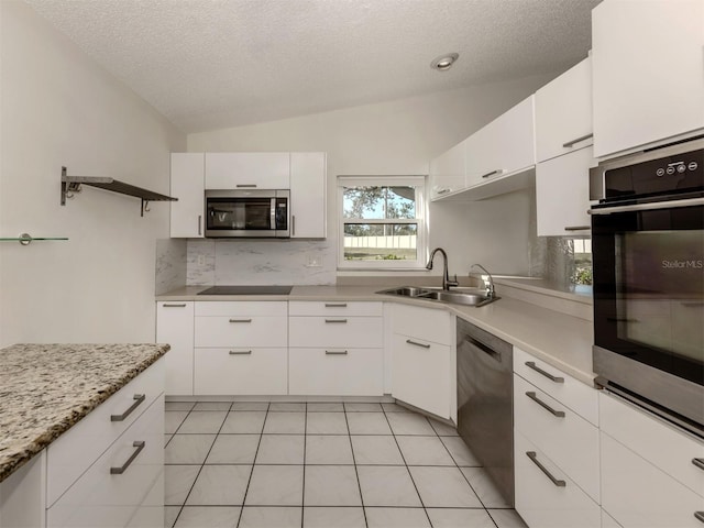 kitchen with white cabinetry, lofted ceiling, sink, and black appliances